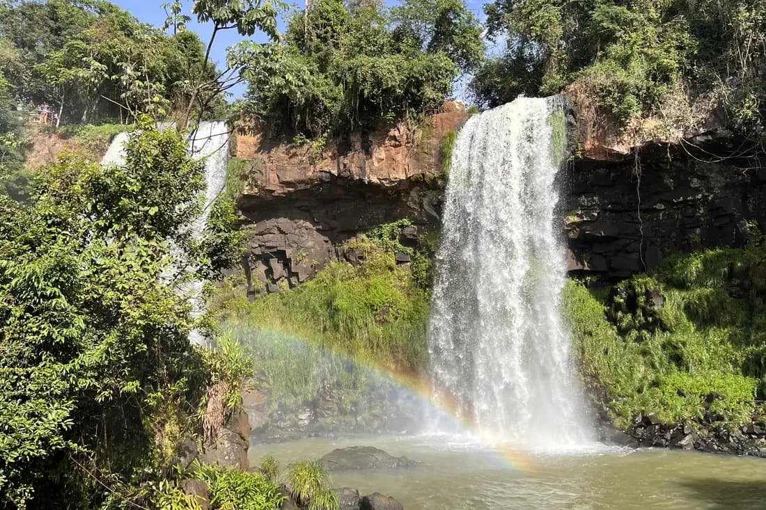 Waterfalls, basalt cliffs and a rainbow framed by forest on the Argentinian side